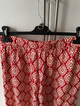 Pantalón fluido estampado rojo y beige.