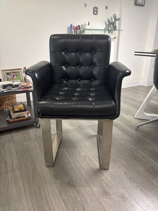 Sillón de piel negro con base metálica