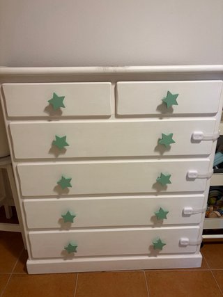 Cajonera blanca con tiradores de estrella.