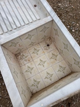 Fregadero de mármol con cubeta y tabla de lavar
