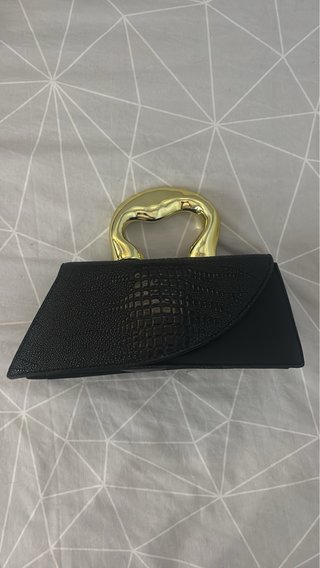 Bolso de mano negro con asa dorada
