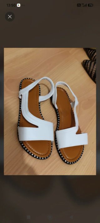 Sandalias planas blancas y marrones.