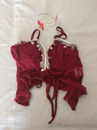 Top granate y pulsera dorada con detalles rojos