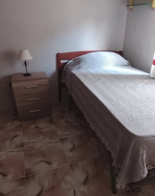 Cama individual con mesita y lámpara