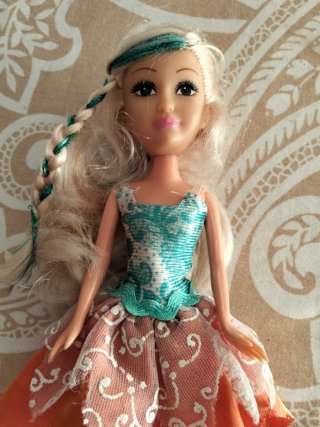 Boneca com vestido laranja e sapatos roxo