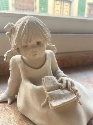 Figura de niña leyendo partitura