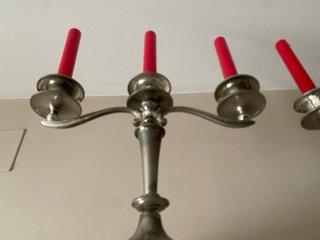 Candelabros de metal plateado con velas rojas