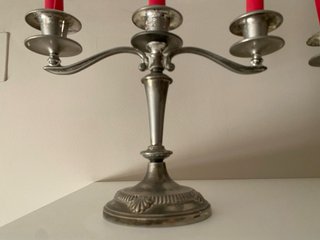 Candelabros de metal plateado con velas rojas
