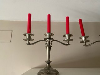 Candelabros de metal plateado con velas rojas