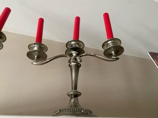 Candelabros de metal plateado con velas rojas