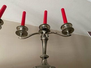 Candelabros de metal plateado con velas rojas