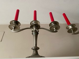 Candelabros de metal plateado con velas rojas