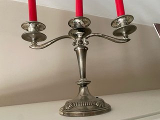 Candelabros de metal plateado con velas rojas