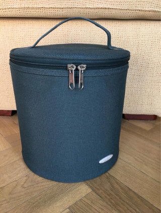 Neceser de viaje semirrígido, verde y redondo.