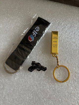 Portachiavi con ciondolo pistola e lingotto oro