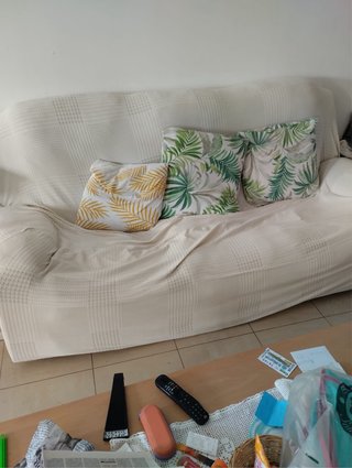Sofá beige con cojines verdes