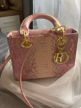 Bolso de mano rosa y dorado con estampado