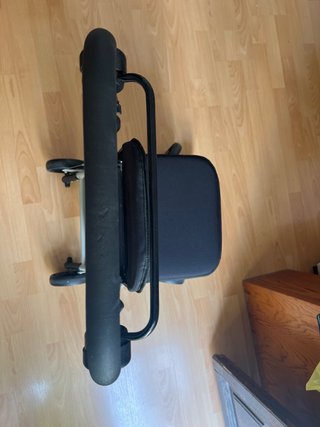 Andador con asiento, ruedas y frenos.
