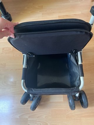 Andador con asiento, ruedas y frenos.