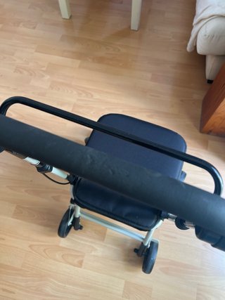 Andador con asiento, ruedas y frenos.