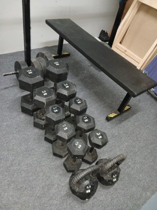 Banco de musculación con pesas y mancuerna