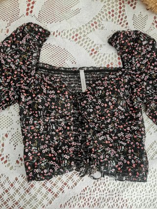 Top negro floral manga abullonada