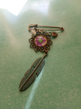 Broche antiguo con pluma y flor