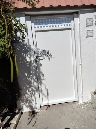 Puerta exterior blanca con reja
