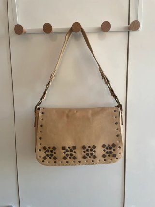 Bolso de cuero beige con tachuelas