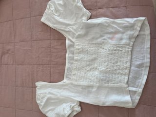 Top blanco con fruncido, tiene una pequeña mancha.