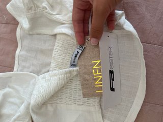 Top blanco con fruncido, tiene una pequeña mancha.