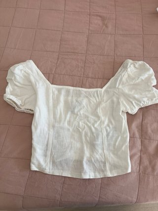Top blanco con fruncido, tiene una pequeña mancha.
