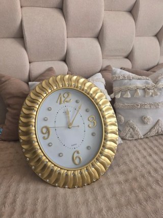Reloj de pared dorado con pedrería