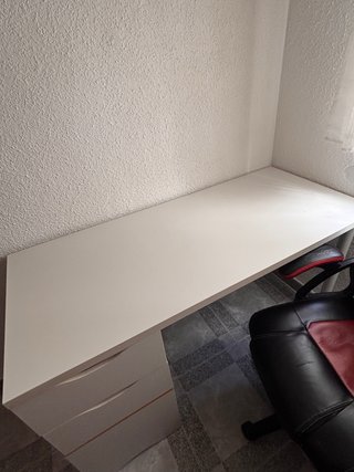 Escritorio blanco con cajones y silla gaming