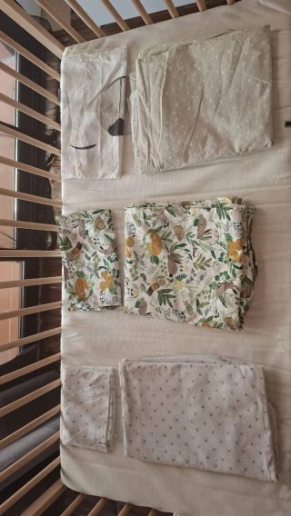 Cuna de bebé de madera con colchón y sábanas