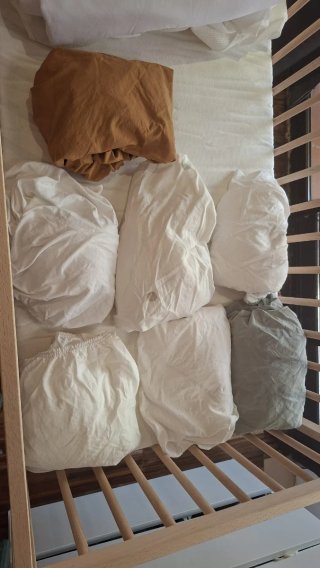 Cuna de bebé de madera con colchón y sábanas
