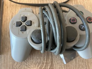 Console PS1 grigia con 3 giochi