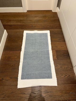 Alfombra pie de cama de algodón azul y blanco.