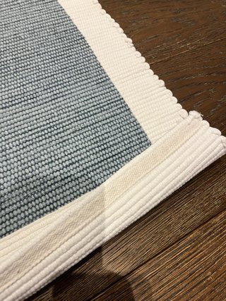 Alfombra pie de cama de algodón azul y blanco.