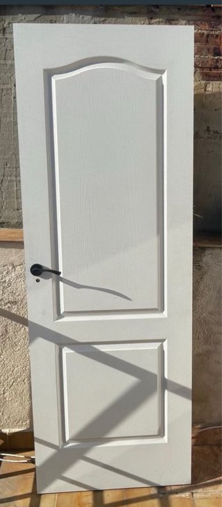 Puerta de madera blanca con manilla