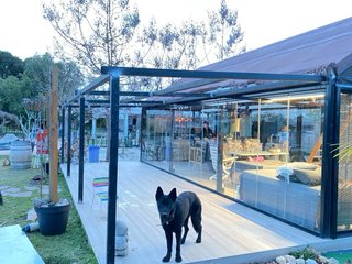 Pérgola acristalada con buhardilla y chimenea