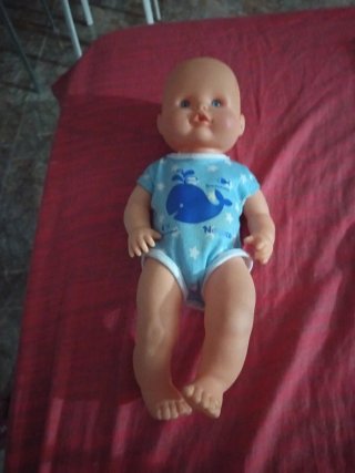 Muñeca bebé con vestido azul y amarillo