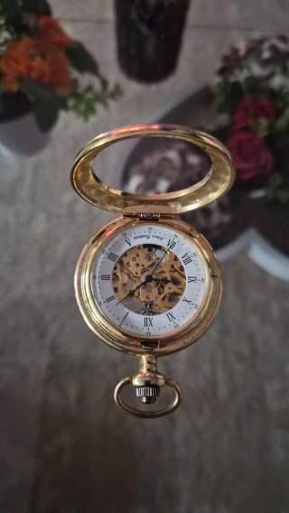 Reloj de bolsillo dorado con mecanismo visible