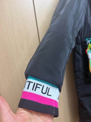Abrigo plumífero negro con detalles multicolor