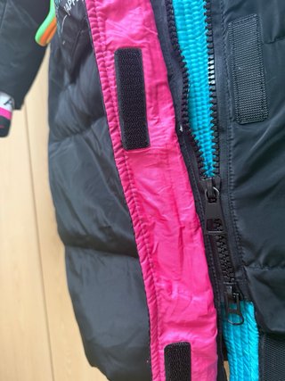 Abrigo plumífero negro con detalles multicolor