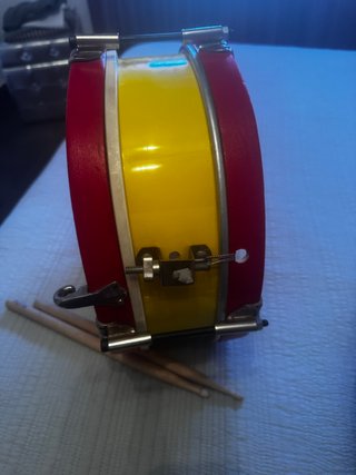 Tambor infantil rojo y amarillo con baquetas