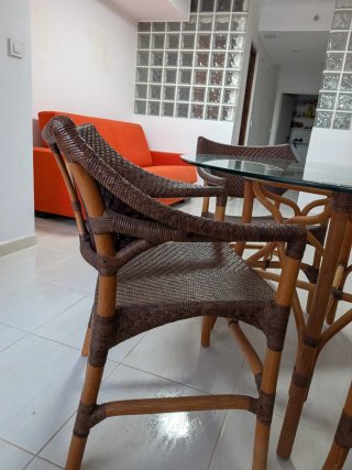 Mesa de comedor redonda de cristal y ratán