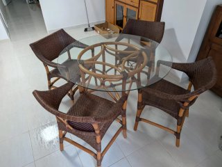 Mesa de comedor redonda de cristal y ratán