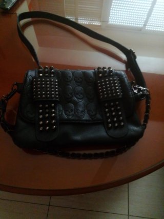 Bolso negro con tachuelas y calaveras