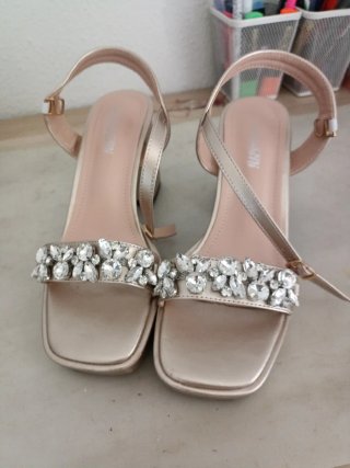 Sandalias doradas con pedrería.